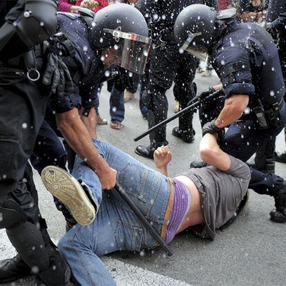 Dos policías arrastrando a un manifestante en la plaza de Catalunya.