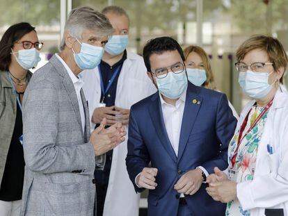 El presidente de la Generalitat, Pere Aragonès (centro), y el consejero de Salud, Josep Maria Argimon, en el hospital de Bellvitge en L'Hospitalet de Llobregat (Barcelona), el domingo.
