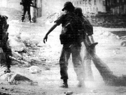 Soldados salvadore&ntilde;os arrastran cad&aacute;veres de campesinos tras una operaci&oacute;n en San Antonio Abad en 1982.