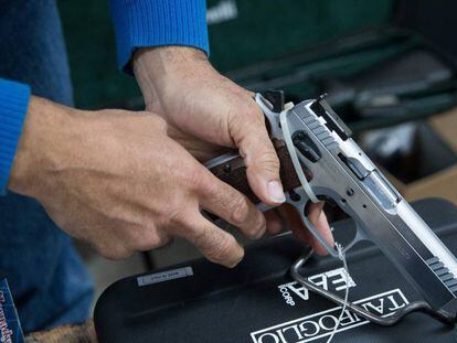 Un hombre ajusta una pistola similar a la que usó el niño contra su hermana.
 