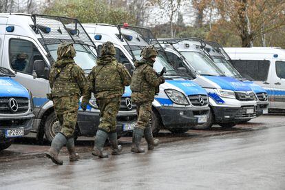 Un equipo de tres militares que peinaban la zona buscando restos de los misiles pasaba por delante de furgonetas policiales desplegadas el jueves en Przewodów.