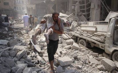 Un hombre traslada a un herido tras un bombardeo contra el bastión rebelde de Idlib en septiembre de 2016.
