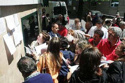 Afectados por la estafa buscan información en el exterior de la sede de Fórum Filatélico en Madrid.