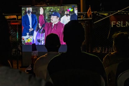 Eine Gruppe von Nachbarn verfolgt auf einem Bildschirm die Einweihungszeremonie von Ortega am 10. Januar in Managua.