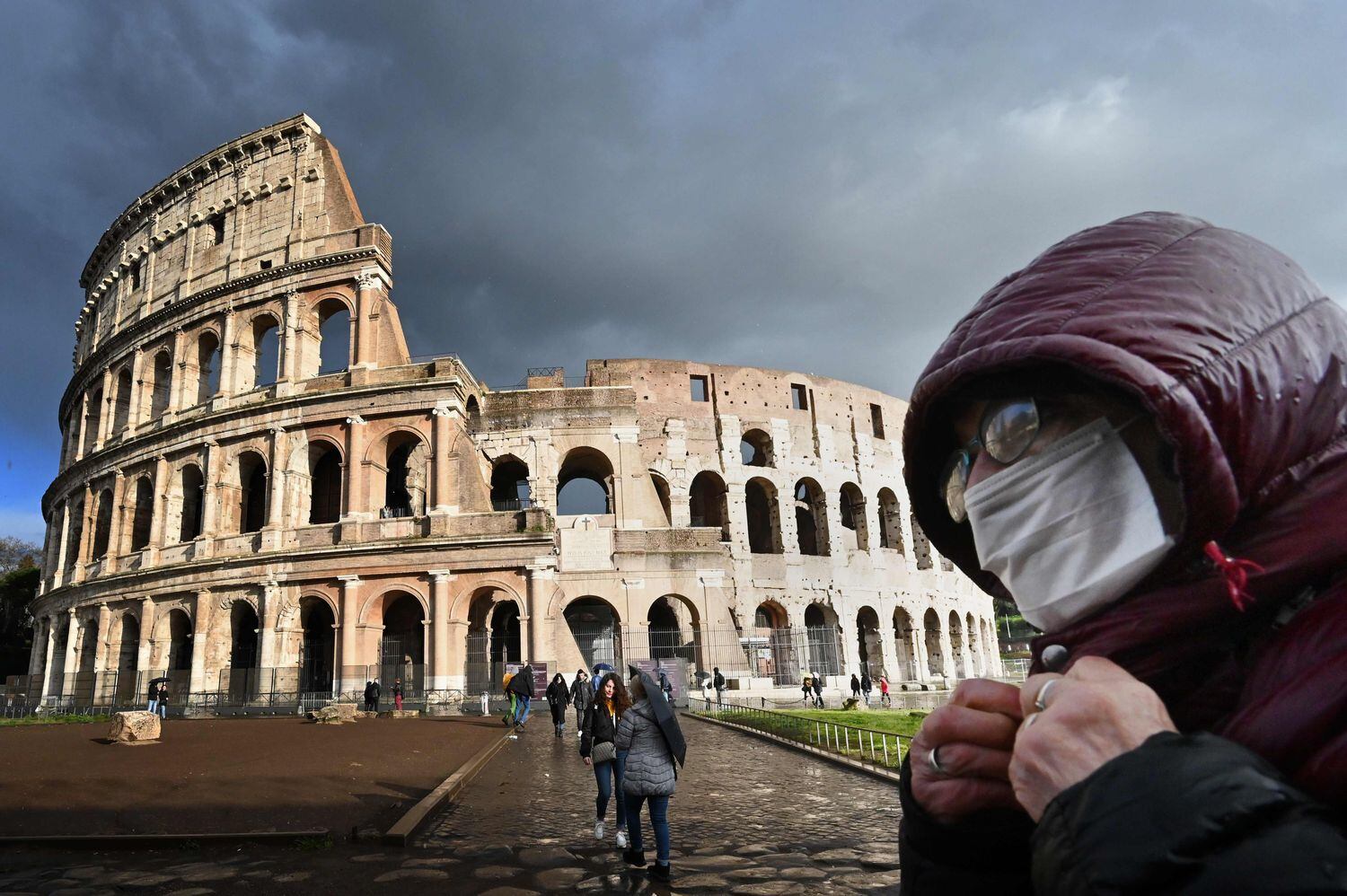 Un hombre con mascarilla pasa ante la puerta del Coliseo, este sábado.