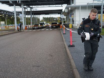 Un guardia fronterizo coloca una cinta en el cruce fronterizo de Vaalimaa, en el Finlandia.