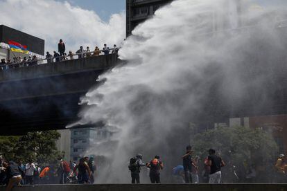 La policía utiliza un cañón de agua para dispersar a los manifestantes, en Caracas.