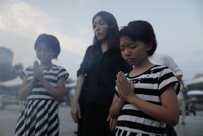 Varias personas rezan por las víctimas durante la ceremonia de conmemoración de las víctimas de la bomba atómica de Hiroshima, en Japón.