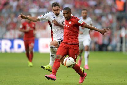  Douglas Costa se lleva un bal&oacute;n ante el acoso de Hilbert del Bayer Leverkusen