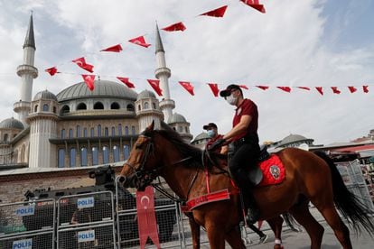 Police and armored officers patrol next to the new Taksim Mosque in Istanbul during its construction in September 2020.