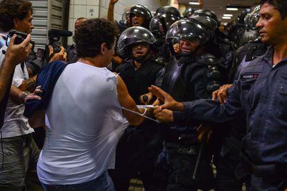 Un hombre con la camiseta rasgada por los miembros de lapolicía en la estación central de tren de Río de Janeriro.