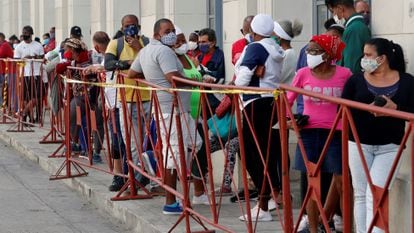 Personas con tapabocas hacen fila en febrero para comprar alimentos en un mercado de La Habana
