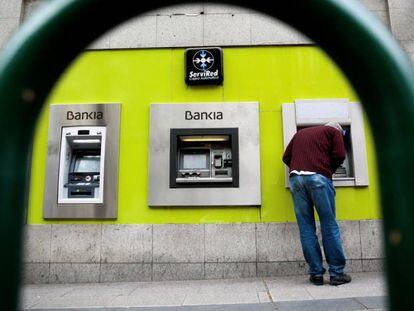 Un hombre utiliza una cajero de Bankia