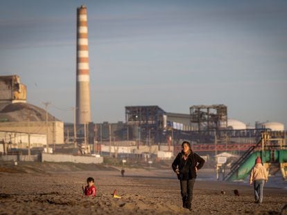 Personas en la Playa Ventanas, en la región de Valparaíso (Chile), junto a una de las fábricas del cordón industrial de la zona.