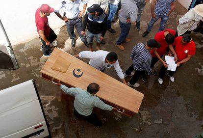 Familiares de un migrante tunecino muerto cargan con su ataúd en la morgue del hospital de Sfax.