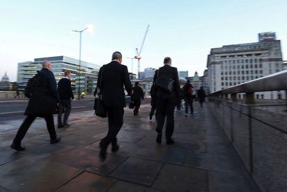 Varias personas cruzan el puente de Londres en direcci&oacute;n hacia a la City, el distrito financiero de Londres