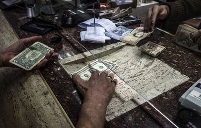 Un comprador recibe d&oacute;lares en una casa de cambio en Caracas.