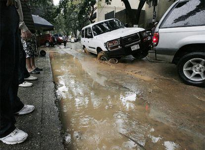 Varios vehículos pasan por una calle inundada después del torrencial aguacero y el terremoto que sacudió Caracas este sábado.