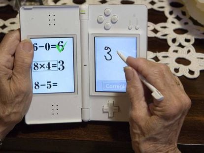 Una persona mayor juega a la aplicación Brain training en la consola Nintendo DS.