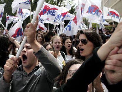 Decenas de manifestantes protestan y muestran banderas a las puertas de la sede central de la radiotelevisión pública griega, en Atenas.