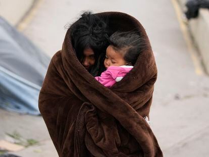 Una migrante venezolna con su hija en brazos se protege del frío en la ciudad de Matamoros (México), el 23 de diciembre de 2022.