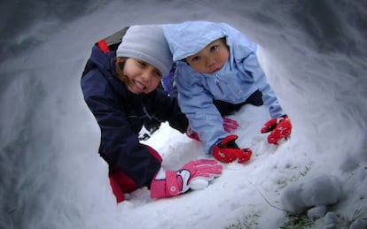 Dos niños construyendo un iglú de nieve en una de las actividades de Solomonte Experiencias, en en Pirineo de Huesca.