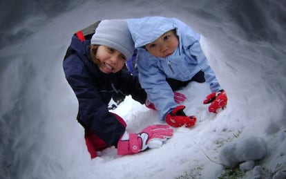 Dos ni&ntilde;os construyendo un igl&uacute; de nieve en una de las actividades de Solomonte Experiencias, en en Pirineo de Huesca.  