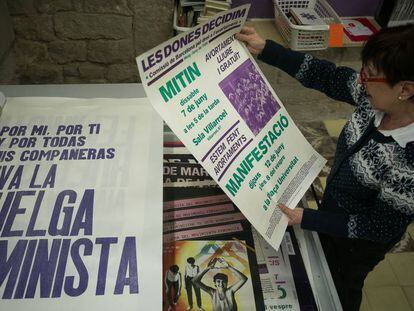 Montserrat, activista del centro de documentación, repasa algunos de los carteles históricos del feminismo, en Barcelona.