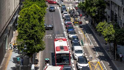 Una panorámica de la calle Colón de Valencia, con dos carriles de la calzada dedicados al transporte público, uno al coche privado, zona de aparcamiento de motos, y el resto a bicis y patinetes,
