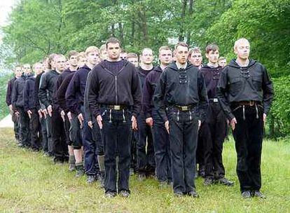 Los participantes en el campamento nazi desmantelado posan en formación militar.