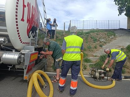 Operarios municipales de Karrantza (Bizkaia) extraen agua de un camión cisterna para incorporarla a la red de suministro.