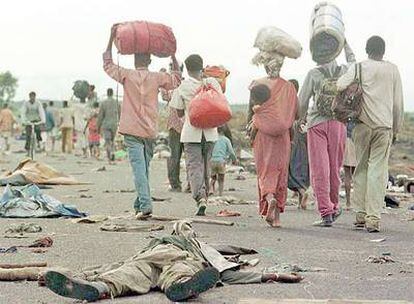 Refugiados hutus ruandeses transitan por una carretera de Zaire a Ruanda ante el cuerpo de un soldado zaireño cerca de Goma en 1996. 
/ reuters
Rafael del Águila.