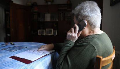 Una pensionista realiza una llamada telefónica desde su domicilio en Madrid.