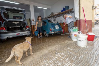 Dos vecinos del barrio de San Ginés de Cartagena (Murcia) limpian el garaje de su vivienda, este martes.