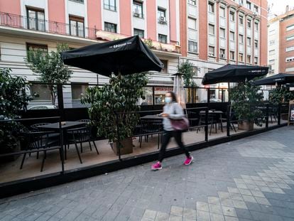 Una mujer pasa junto a una terraza en la calle Gaztambide, en Madrid; el 1 de febrero de 2022.