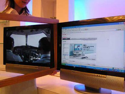 Una empleada de Sharp sostiene un espejo para mostrar las dos imágenes que proyecta la nueva pantalla plana.