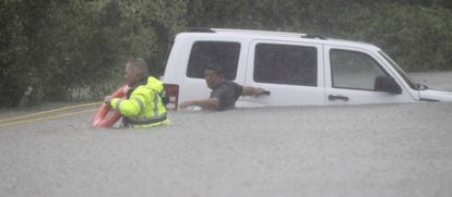 Un agente del sheriff rescata a un hombre de su coche en Houston, el domingo.