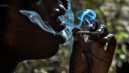 Una persona fuma un porro en un bosque de Kenia.