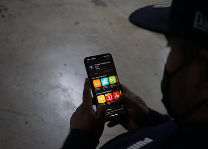 Un hombre descarga en su teléfono móvil una solicitud de préstamo que en realidad funciona como cobrador de deudas, una especie de extorsión telefónica.