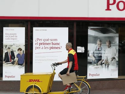 Un repartidor pasa ante una oficina del Banco Popular. EFE/Andreu Dalmau/Archivo