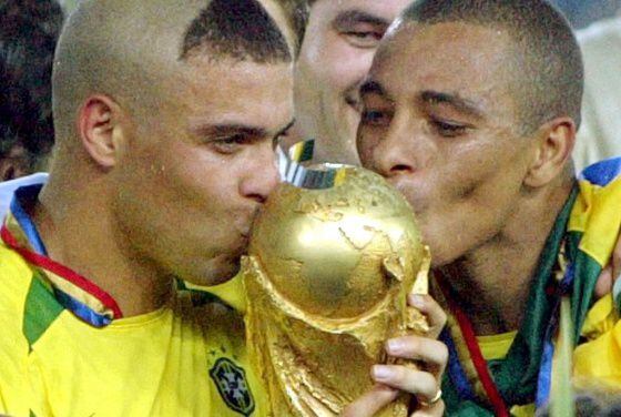Ronaldo y Kleberson besan la Copa del Mundo conquistada por Brasil en 2002.