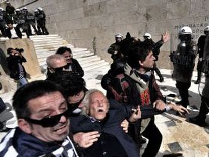 Manolis Glezos es auxiliado tras ser golpeado por la policía durante una protesta en marzo de 2010 en Atenas