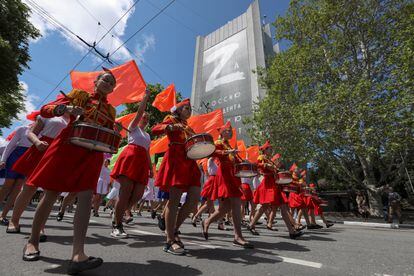 En un momento del desfile realizado en Sebastopol, la marcha pasa por delante de un edificio con una pancarta de la letra Z.