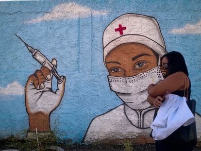 Una mujer camina junto a un mural que busca promover la vacunación contra la covid-19, en Río de Janeiro (Brasil), el 31 de julio de 2021.