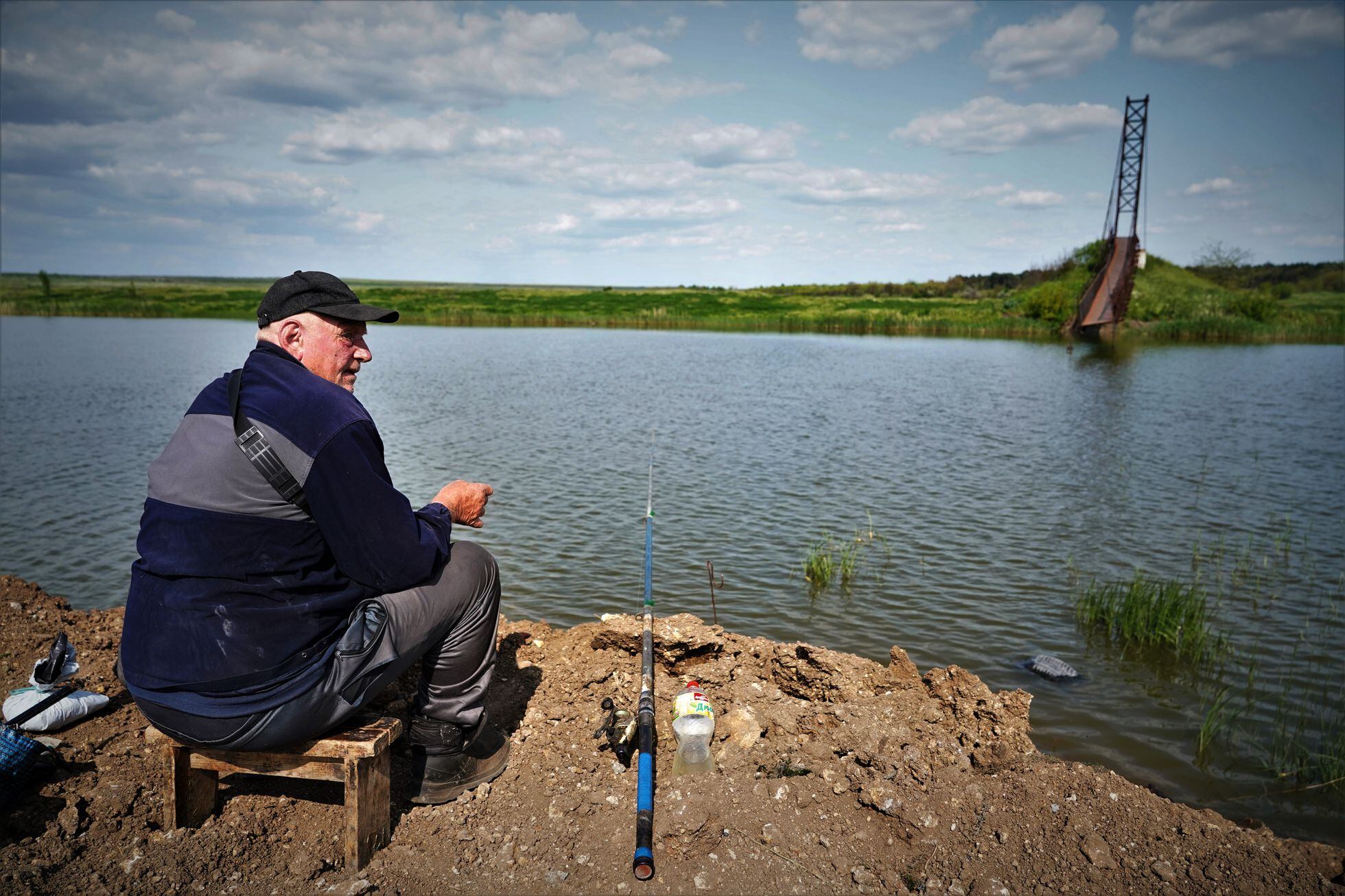 Volodímir Kredovskii, de 63 años, es el guarda de un puente destruido sobre el río Ingulets a su paso por Snigurivka, donde pesca mientras vigila.