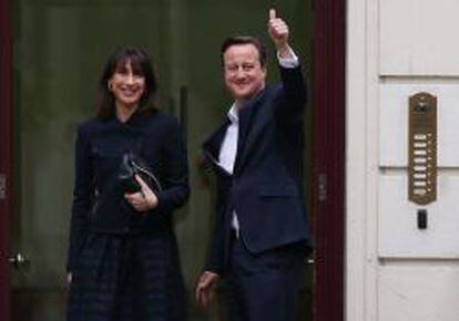 El primer ministro David Cameron, llega a Londres con su esposa Samantha.