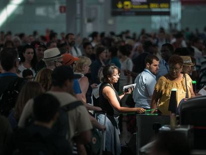 Viajeros pasan el primer control de seguridad tras hacer cola en El Prat.