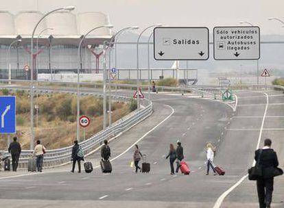 Un grupo de pasajeros accede a pie a la Terminal 4 de Barajas. Los taxistas los dejaron a 500 metros para evitar a los piquetes.