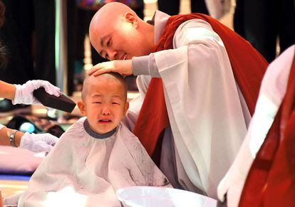 Monjes budistas afeitan la cabeza de un niño durante la ceremonia 'Niños que se convierten en monjes budistas', en el templo de Jogye, Seúl.
