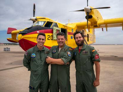 Los pilotos David Juan Conde, izquierda, y Aitor Bellido, derecha, posan junto al mecánico Juan Sánchez frente al hidroavión que tripulan en la base militar de Torrejón de Ardoz en Madrid.